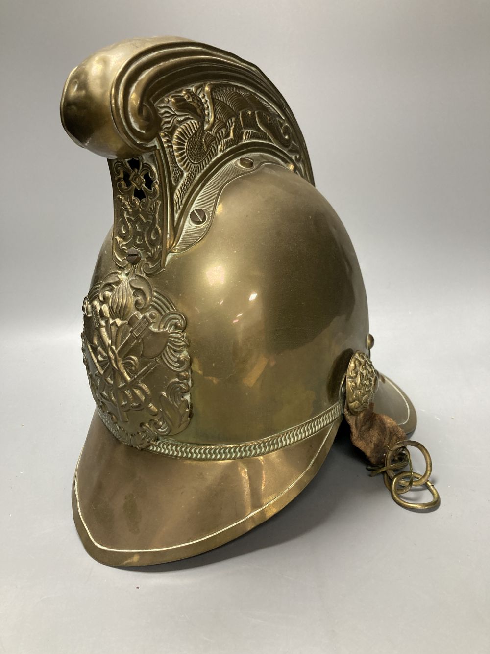 An early 20th century brass firemans helmet, 17cm